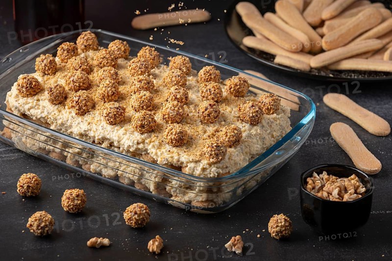 Ready tiramisu with nut balls surrounded by bisque and nuts