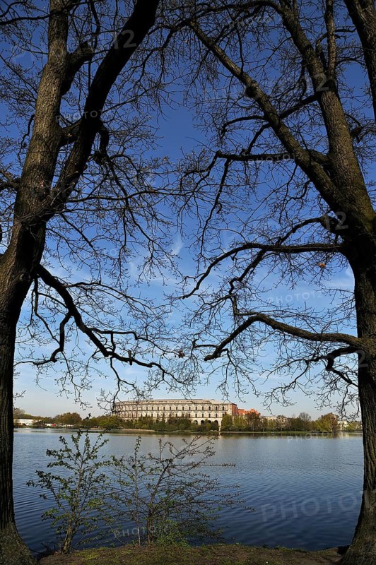 A general view of the former, unfinished NSDAP Congress Hall, 1933–1945, with the Dutzenteich and lime trees (Tilia platyphyllos) in the foreground, Documentation Centre, Reich Party Rally Grounds, Bayernstraße 110, Nuremberg, Middle Franconia, Bavaria, Germany