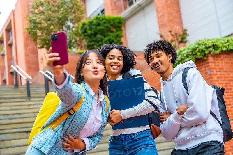 Three multi-ethnic friends taking a selfie in the campus of the university