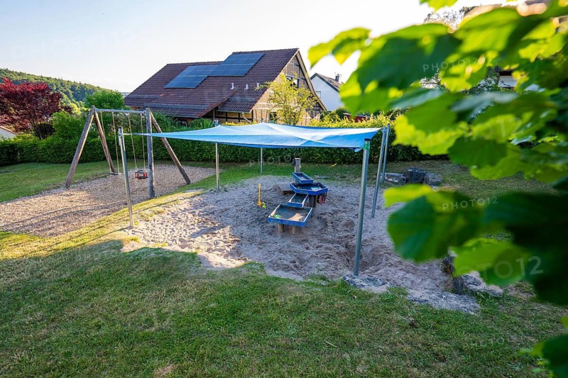 A playground with awning over sandy areas in a quiet residential area, Playgrounds Gechingen, Calw district, Germany