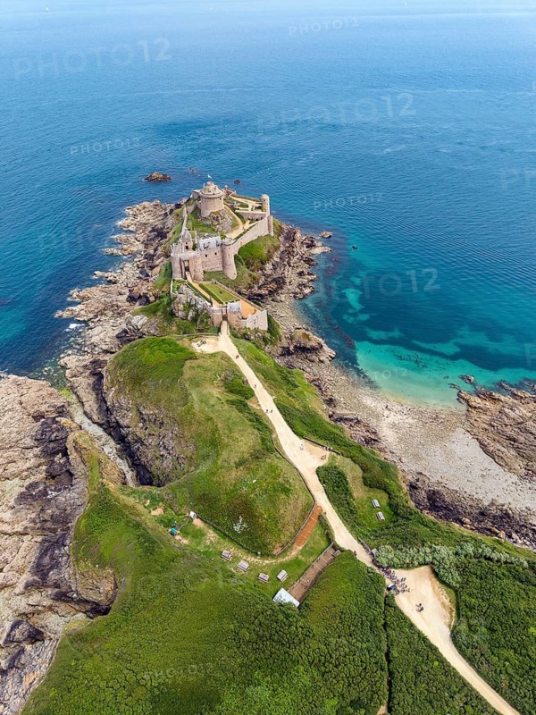 Aerial view of the historic rock castle Fort la slat, Château de la Roche Goyon on a rocky headland on the Emerald Coast, surrounded by the turquoise Atlantic Ocean, Plevenon, Côtes-d'Armor department, Brittany region, France