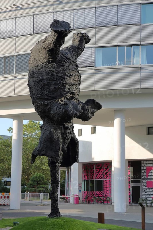 Gran Elephant Dret sculpture by Miquel Barceló 2025, modern art, large sculpture, black elephant figure standing upside down, turned upside down, handstand, symbol for balancing, modern building, glass building, emblem, telecom headquarters, Gronau, Bonn, North Rhine-Westphalia, Germany
