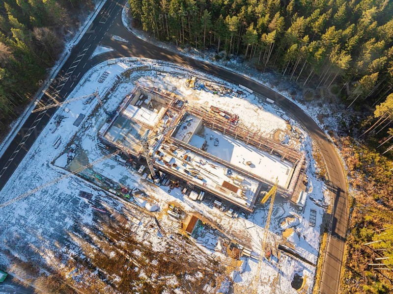 Top view of a construction site in the forest, surrounded by a road, winter snow, new fire station, Oberhaugsett, district of Calw, Germany