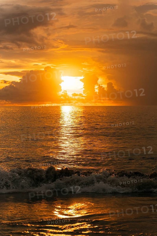 Breathtaking sunset over the ocean in Bali, Indonesia. Golden hues reflect on the sea, creating a mesmerizing and peaceful atmosphere. Perfect for travel and nature themes