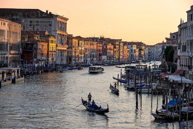 View of the Grand Canal with gondoliers at sunset, picturesque evening mood with palazzos on the canal, view from the Rialto Bridge, Venice, Veneto, Italy