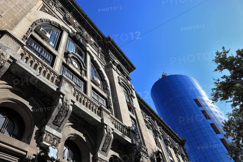 In the centre, office building, bank building, historic post office building and police building reflected in the modern BCR bank building, Bucharest, Romania
