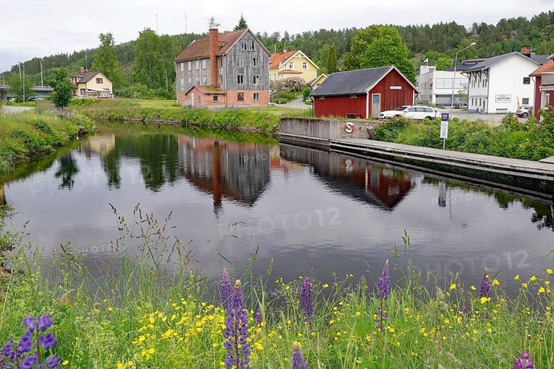 Small village with colorful houses on a canal. Summer atmosphere and green shores, Bengtfors, Dalsland Canal, Västra Götalands län, Sweden