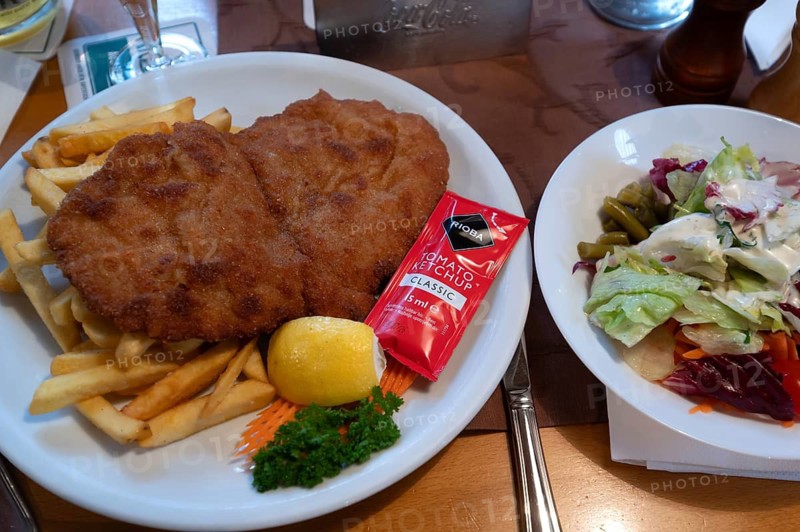 Wiener schnitzel with French fries and salad, served in a tavern, Franconia, Bavaria, Germany