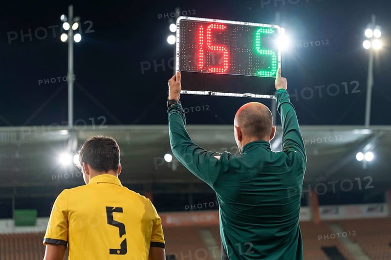 Sideline referee shows players substitution during football match at stadium in Lubin, Poland