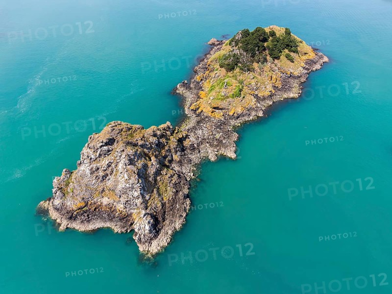 Aerial view of the distinctive rock formation and tidal island of Pointe de la Chaîne on the Emerald Coast. Turquoise sea surrounds rocky headland with sparse vegetation, Cancale, Côte d'Émeraude, Emerald Coast, Ille-et-Vilaine department, Brittany, English Channel, France