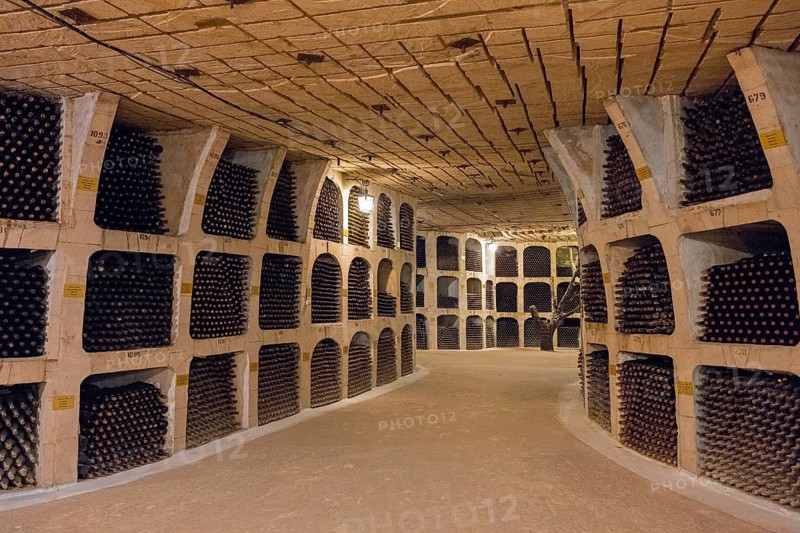 Round corridor in a wine cellar with densely stacked bottles and dim lighting, wine cellar, Milestii Mici Winery, Mile?tii Mici, Republic of Moldova, Moldova