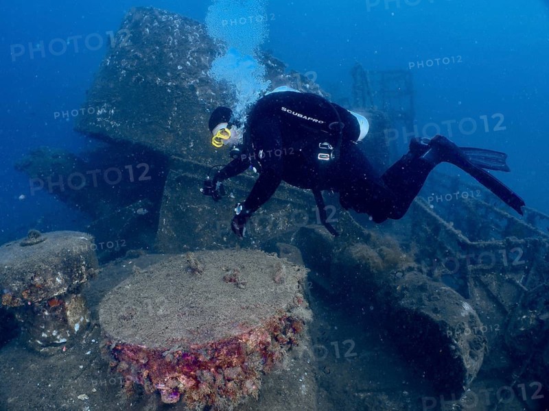 Diver examines an overgrown underwater wreck, dive site wreck of the Vis, Pula, Croatia, Mediterranean
