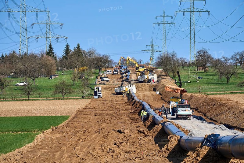 Large pipeline construction site for future gas and hydrogen energy supply across agricultural landscape. Workers and machinery install underground pipes. Großingersheim, Ludwigsburg district, Baden-Wuerttemberg, Germany