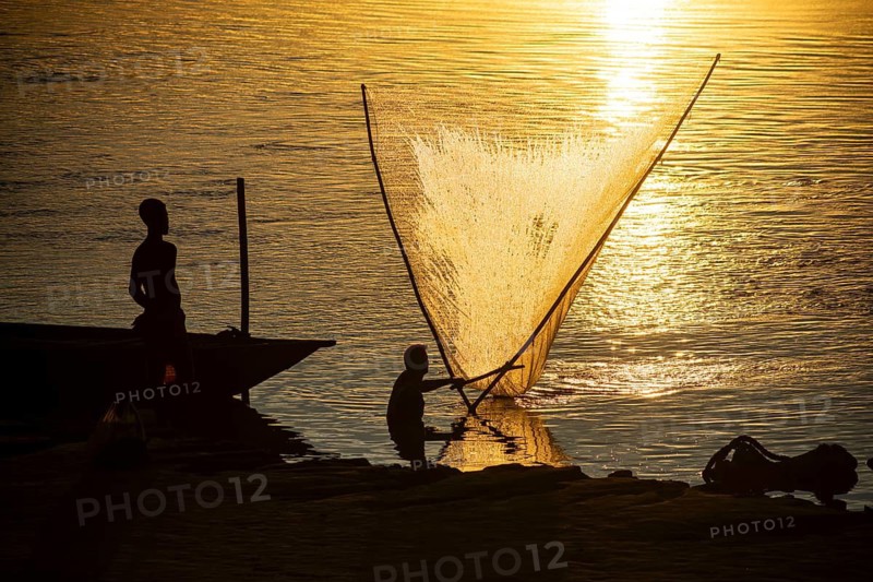 Fishermen fishing in the Brahmaputra river, during sunset in Guwahati, Assam, India on 1 August 2023