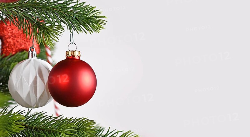 Banner with ball shaped red Christmas baubles on Christmas tree on side of gray white background with copy space