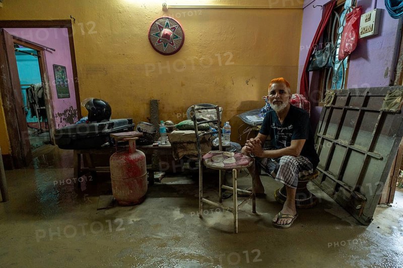 Resident sit inside his mud-filled and flood-damaged home after floodwaters receded on July 26, 2026 in Sivasagar, India. The flood situation in Assam has improved following the recession of floodwaters. However, more than 700, 000 people across 21 districts have been affected by the floods, while the state's death toll has risen to 60