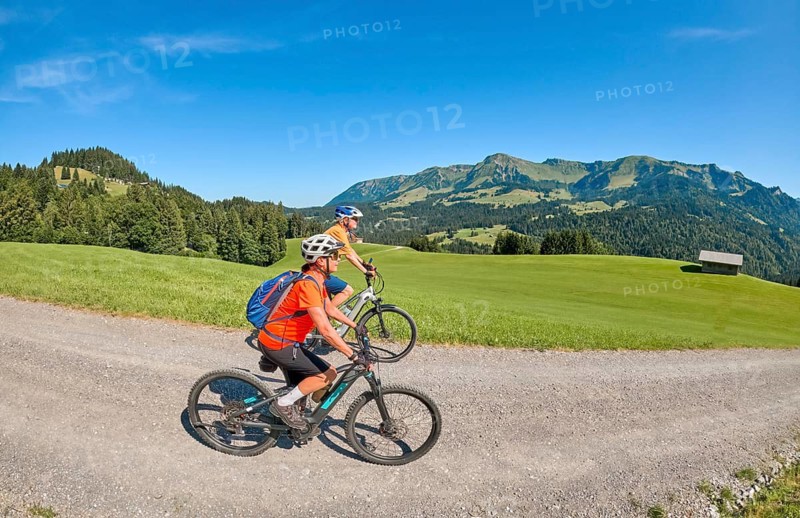 Two senior girl friends have fun during a ebike cycling tour in the Bregenz Forest near Sibratsgfäll, Vorarlberg, Austria