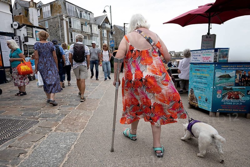 Elderly woman from behind, on stick, running with dog, St Ives, Cornwall, England, Great Britain, Great Britain