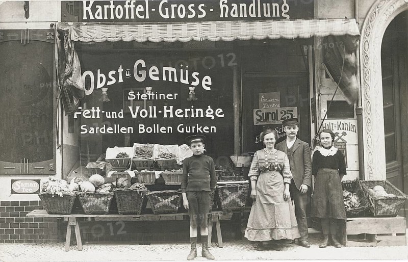 Szczecin, potato wholesaler, fruit and vegetables, fiche, herrings, bollen, cucumbers, anchovies, shop, sale, owner, saleswoman, boy, display, vegetable baskets, old vegetable shop front with a family and baskets full of vegetables in front of it, 1913