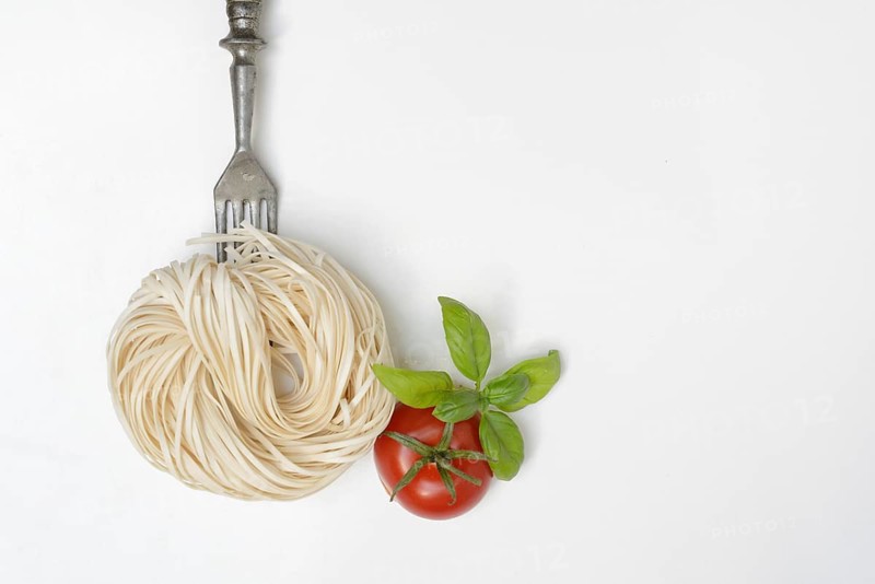 Spaghetti with fork and tomato, cutlery