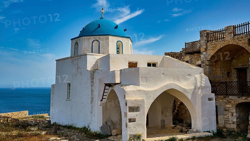 White church with blue dome by the sea, surrounded by old stone walls under a blue sky, Church of Agios Georgios, Chora, Astypalea, Dodecanese, Greek Islands, Greece