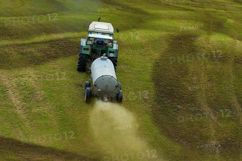 Tractor spreading liquid manure on a green field, meadow, Bavaria, Germany