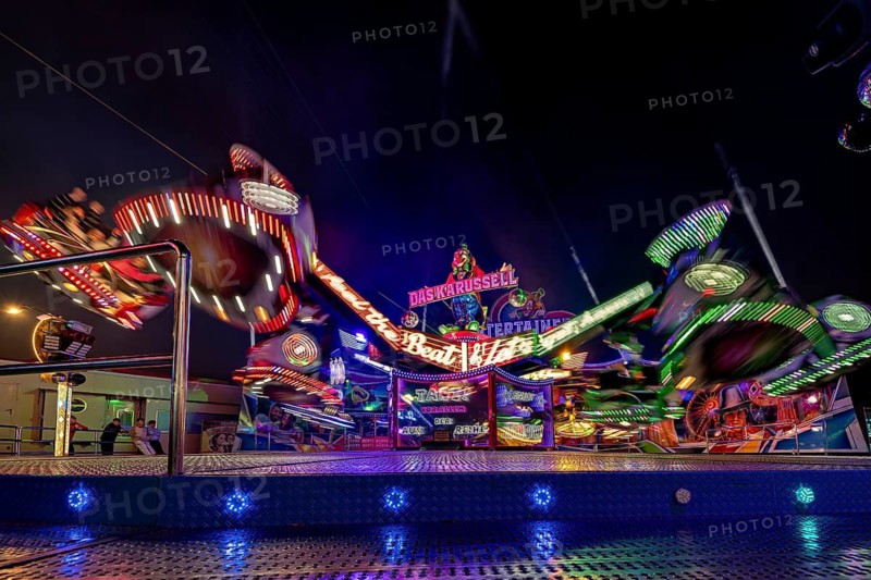 A carousel at a fair at night, with colorful lights in motion, carousel and the hustle and bustle of summer winnings in Eisenach