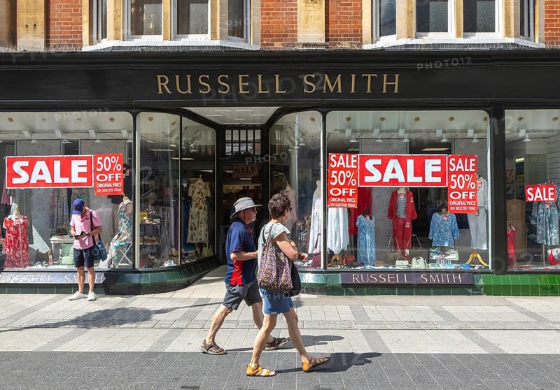 Sale posters in shop window of Russell Smith clothes shop, town centre of Felixstowe, Suffolk, England, UK