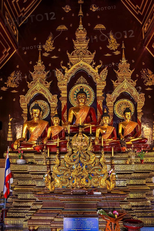 Seated gilded Buddha figures in a public prayer room of a Buddhist temple complex, Old City Center, Chiang Mai, Thailand