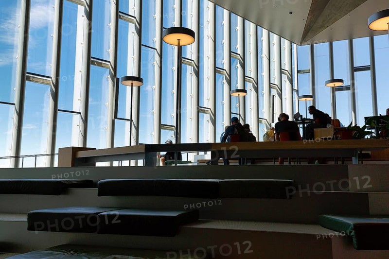 Interior of the Deichman Bjørvika Library, visitors in front of glass façade, city library, terraced seating elements and steps, reading, meeting places or workplaces, Oslo, Norway