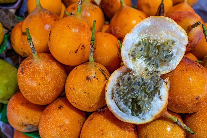 A broken, sweet, exotic granadilla fruit lies on a heap of granadillas, market hall, weekly market market, Arequipa, southern Peru, Peru, South America
