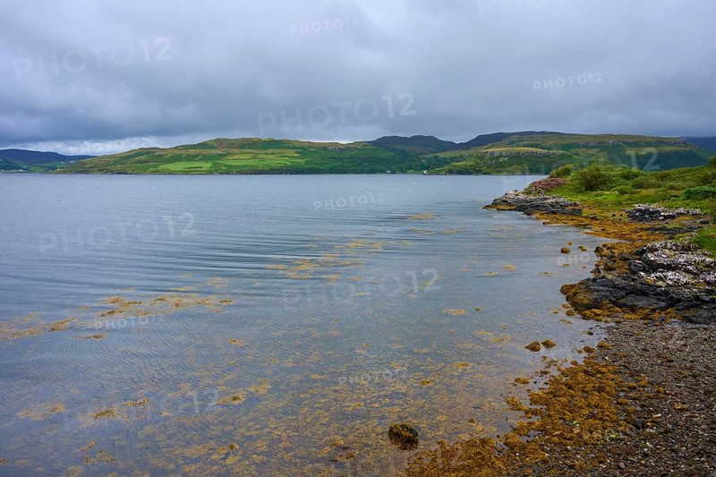 Lake with calm cloudy sky and green hills in the background, Portnalong, Isle of Skye, Scotland, United Kingdom, United Kingdom