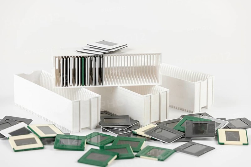 A mix of white and green slides surrounds white slide holders in a messy scene