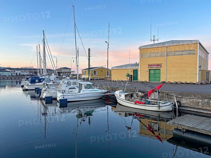 Quiet harbor with boats against an evening sky and colorful buildings, Nexö, Bornholm, Denmark