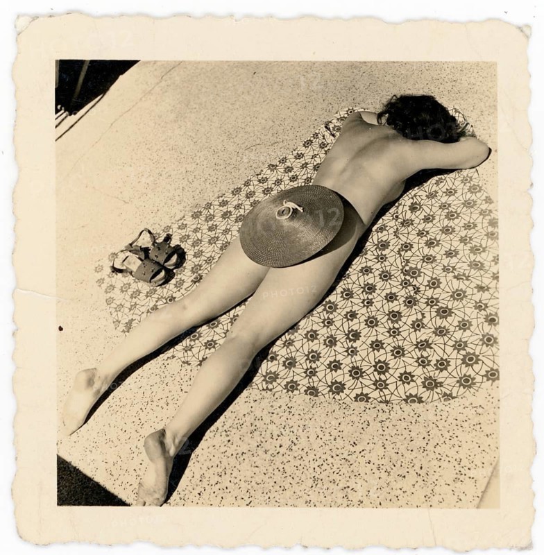 Bathing, swimwear, sunbathing, summer, woman lying on the ground and basking on a patterned surface, sunhat, humor, around 1950