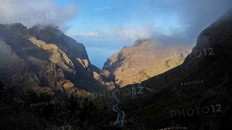 Dramatic mountain scenery with winding road and mystical fog illuminated by sunbeams, Masca, Barranco de Masca, Gorge, Teno, Teno Mountains, Northwest Tenerife, Tenerife, Canary Islands, Spain