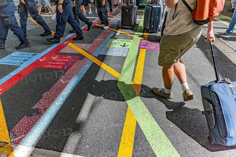 Travelers in the train station. Passengers at Stuttgart Central Station. Signage for alternative traffic. Coloured markings on the floor show the right path. It is complicated. Stuttgart, Baden-Württemberg, Germany
