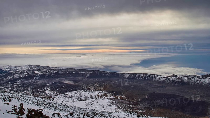 From Pico del Teide, Teide summit, panoramic views over snow-covered mountains and underlying clouds under a cloudy sky, Teide National Park, Teide National Park, volcano, volcanism, UNESCO World Heritage Site, Tenerife, Canary Islands, Spain
