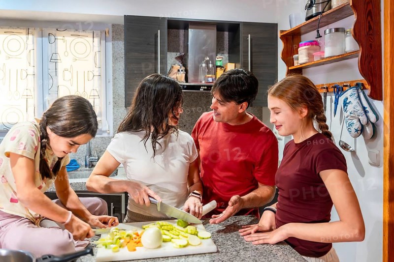 Family cooking vegetables on a cutting board, parents and daughters bonding in a domestic kitchen while preparing a healthy meal for dinner, fostering togetherness and healthy lifestyle
