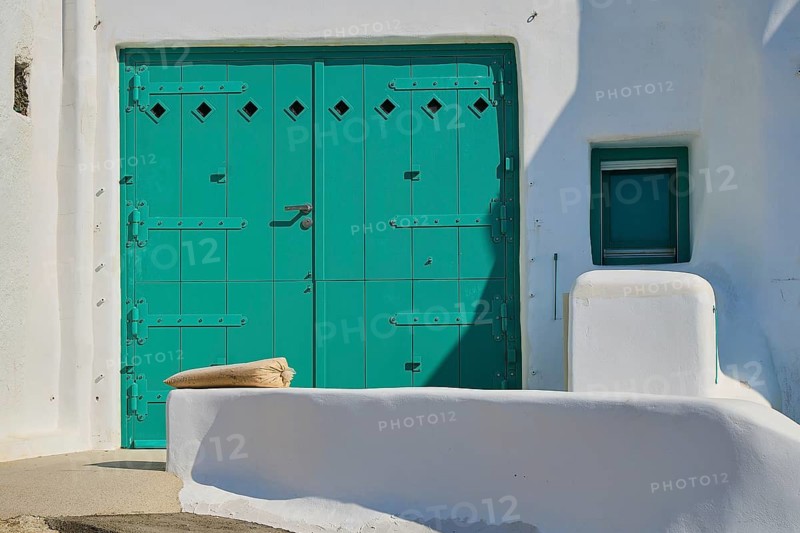 Close-up of a large green door at a white minimalist house with Mediterranean flair, Syrmata, boat garages, boathouse, boathouses, beach house, Goupa, Goypa, Goupa Kara, Kimolos, Cyclades, Greek Islands, Greece