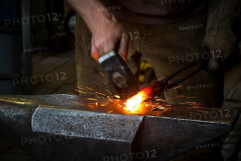 Sparks spray, a blacksmith forging, working at the Ehnert forge in Dresden-Bühlau, Saxony, Germany