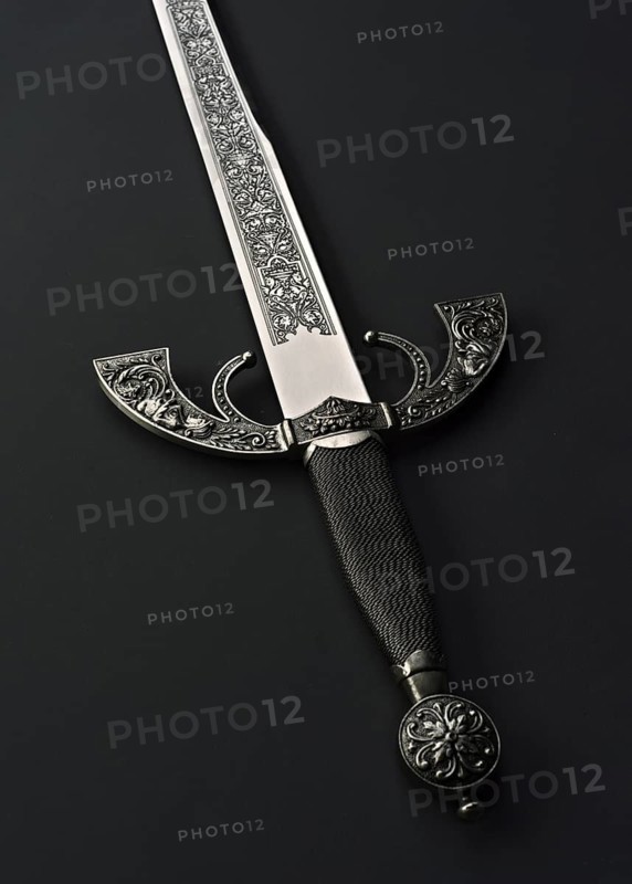 This image features an intricately designed Spanish steel sword with a detailed handle and blade, set against a black background. The sword displays classic crafting techniques, showcasing beautiful decorative metalwork