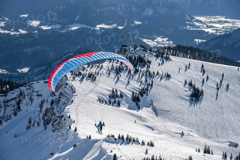 Mountains in winter, paraglider with skis on Sonntagshorn, Chiemgau Alps, Bavaria, Germany