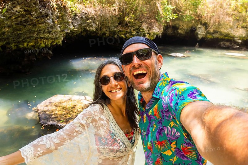 Portrait selfie couple man woman travelers wear vibrant tropical shirt takes pose in Baraka Natural Aquarium. Concept joy, fun and freedom sightseeing secluded Zanzibar turtle sanctuary