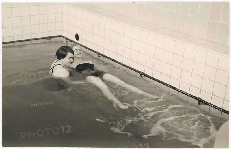 Swimming lessons, bathing establishment, Two woman in a swimming pool relaxing in the water in a vintage setting, around 1933