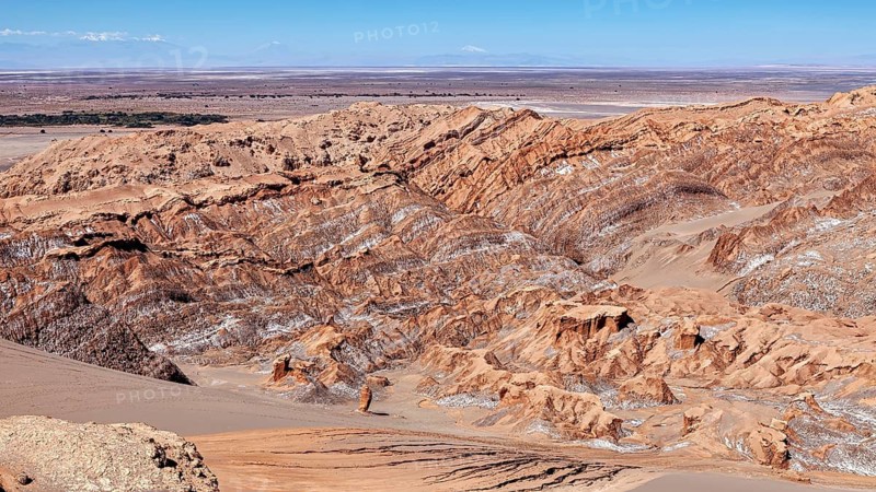 Sandy, steep rock formations in a vast desert landscape under blue skies, The Moon Valley in the Atacama on the Altiplano in the Aden near San Pedro de Atacama in Chile