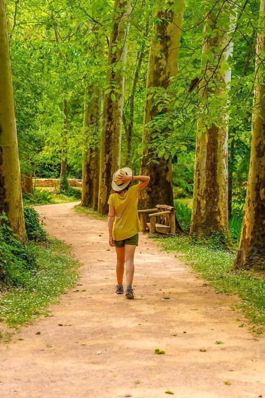 A woman walking through a forest in the Monasterio de Piedra Natural Park, Aragon