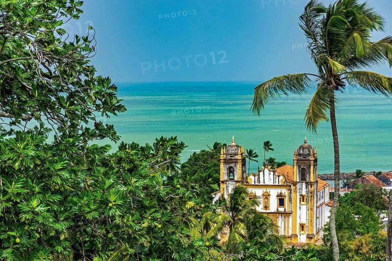 Antique baroque church between vegetation and the sea in the city of Olinda in Pernambuco, Olinda, Pernambuco, Brazil