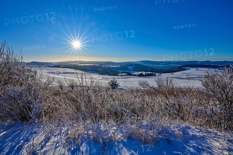 Landscape with bright sun and snow-covered hills, winter, Wasserkuppe, Gersfeld, Rhön, Hesse, Germany