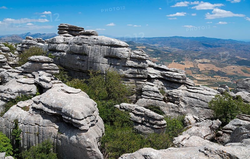 High cliffs and mountain landscape under a clear blue sky, in the background wide fields and mountain ranges, karst mountains, Torcal Alto, El Torcal de Antequera, Sierra del Torcal, Malaga, Andalusia, Spain